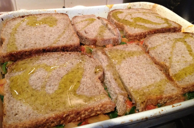 several sandwiches are in the baking dish ready to be put into the oven