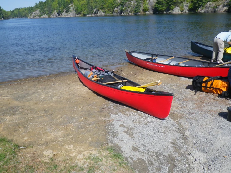 two red canoes on the shore of a river