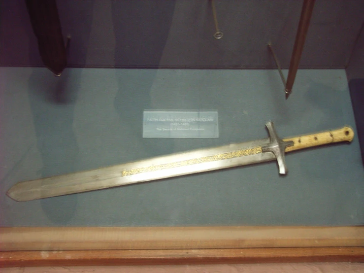 a knife on display in a museum with blue background