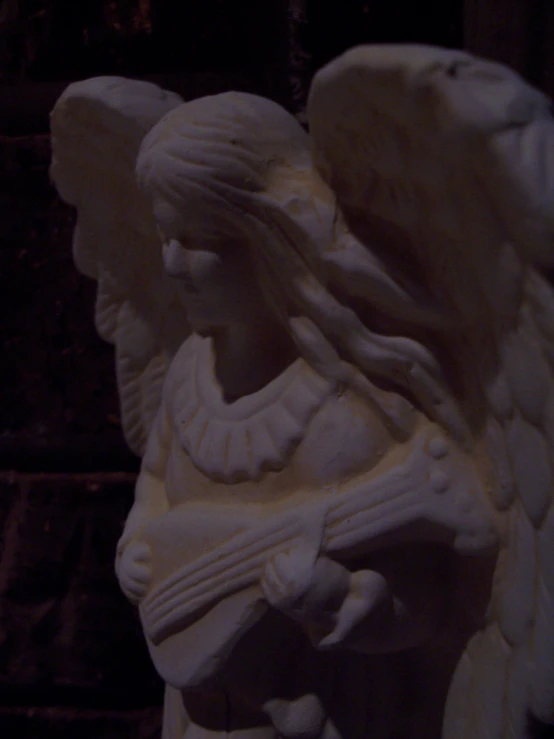 there is a statue that is white and has an angel on it