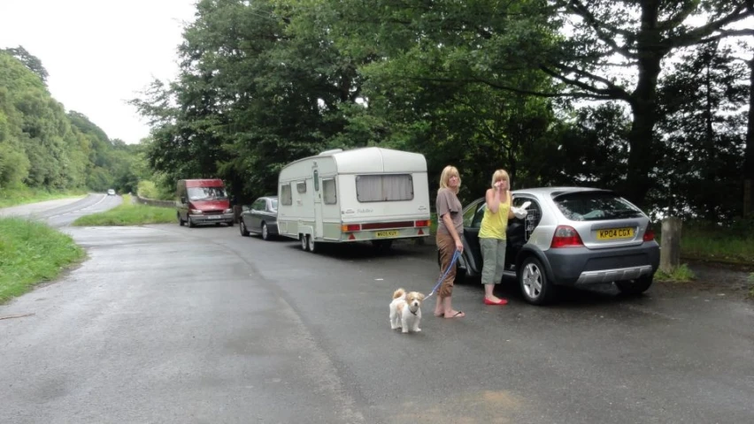 a woman and two children are standing next to an open car trunk