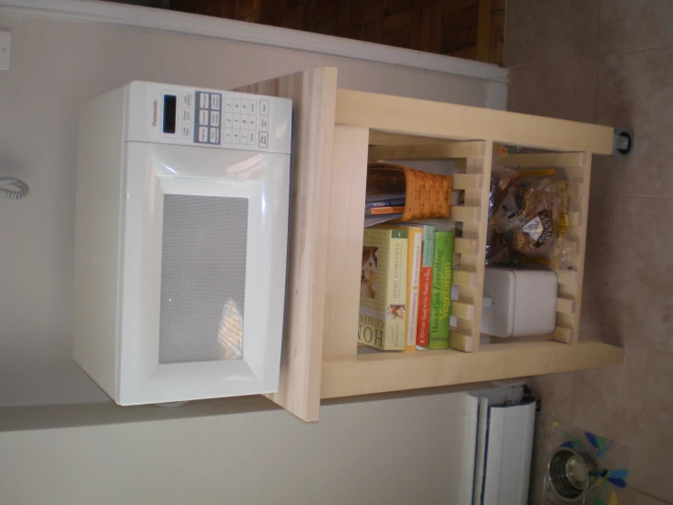 a microwave sitting on top of a wood shelf