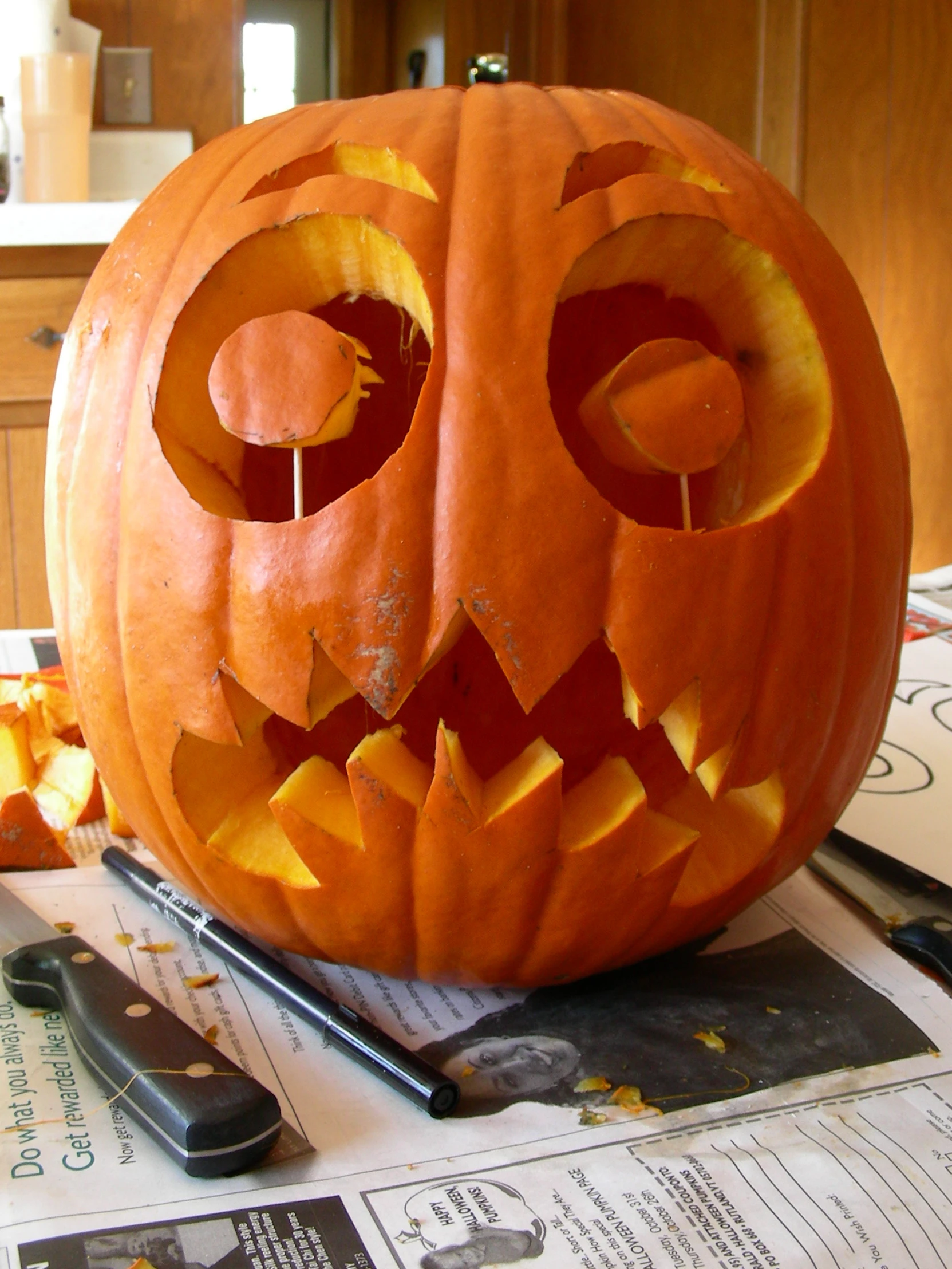 a pumpkin with a carved face sitting on top of a  board