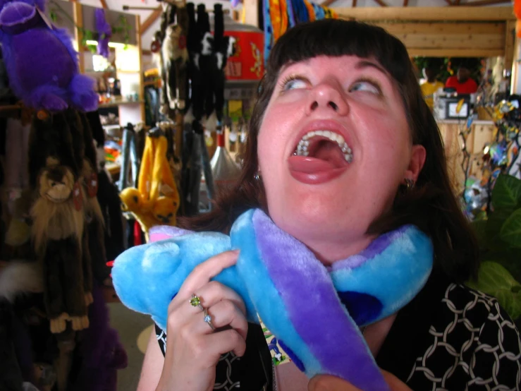 a girl holding a stuffed toy and making a shocked face