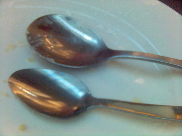 there are two metal spoons with rust on them