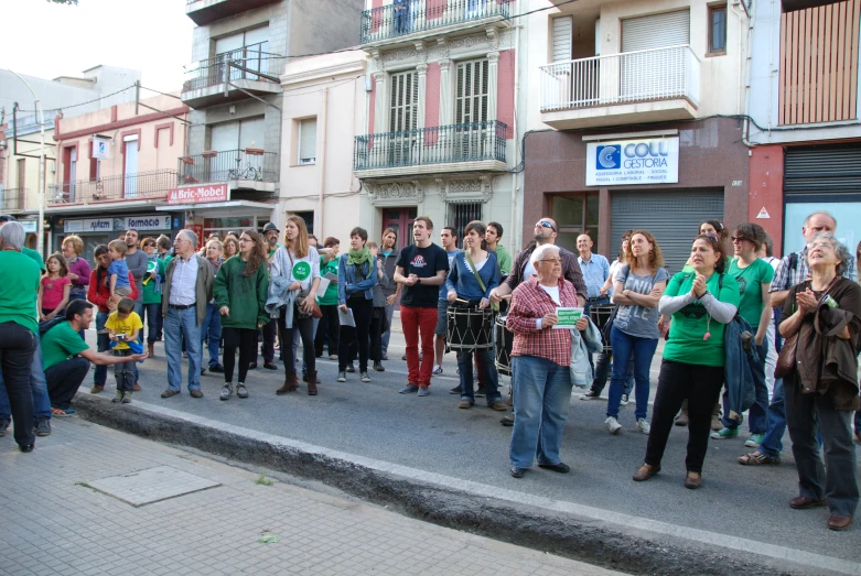 there are people walking in a crowd down the street