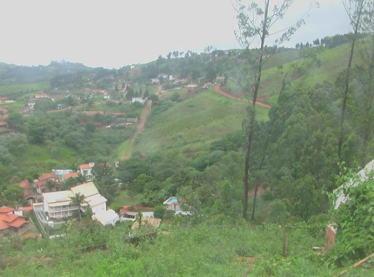an overview of a village with houses, trees and hills