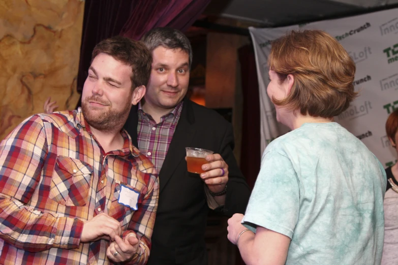 a group of men holding up a glass of beer