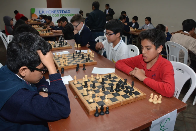 a man plays a game of chess with his son