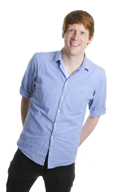a smiling man in a blue shirt and black pants