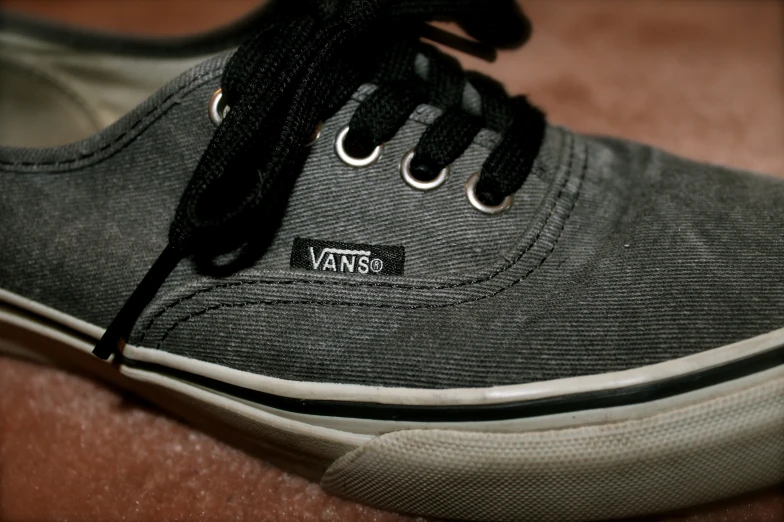 black and gray canvas vans shoes with a small white box