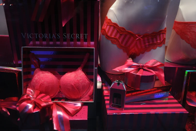 two red lingeries are laying on display next to a bottle