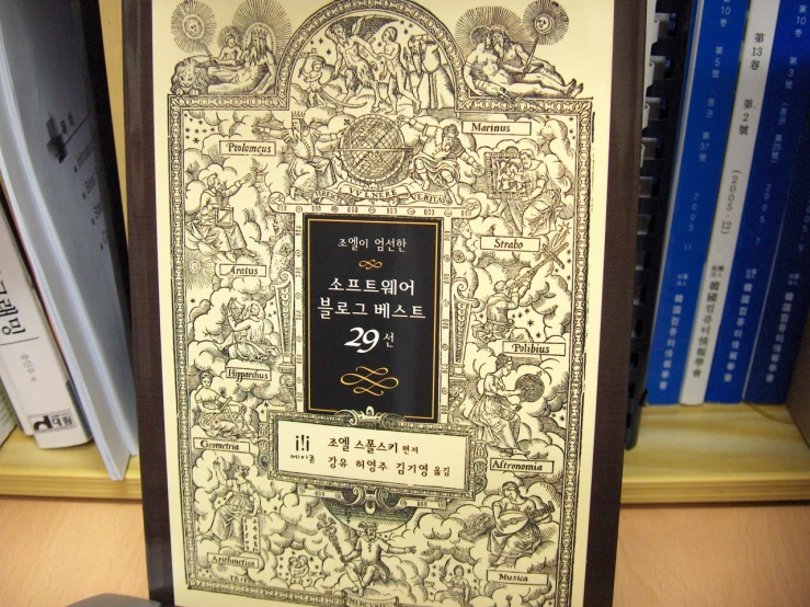 a book about japanese writing with gold border on wooden shelves