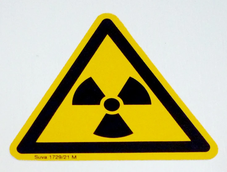 a yellow sign with black words is indicating radiation