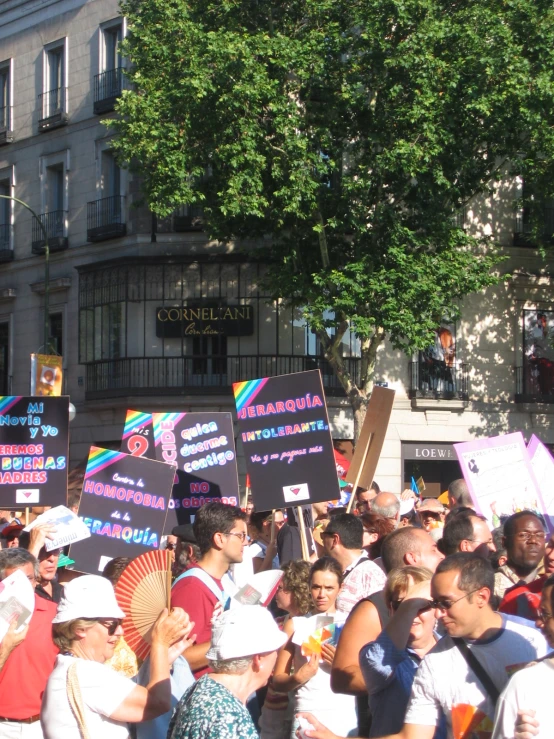 a crowd of people are outside holding signs
