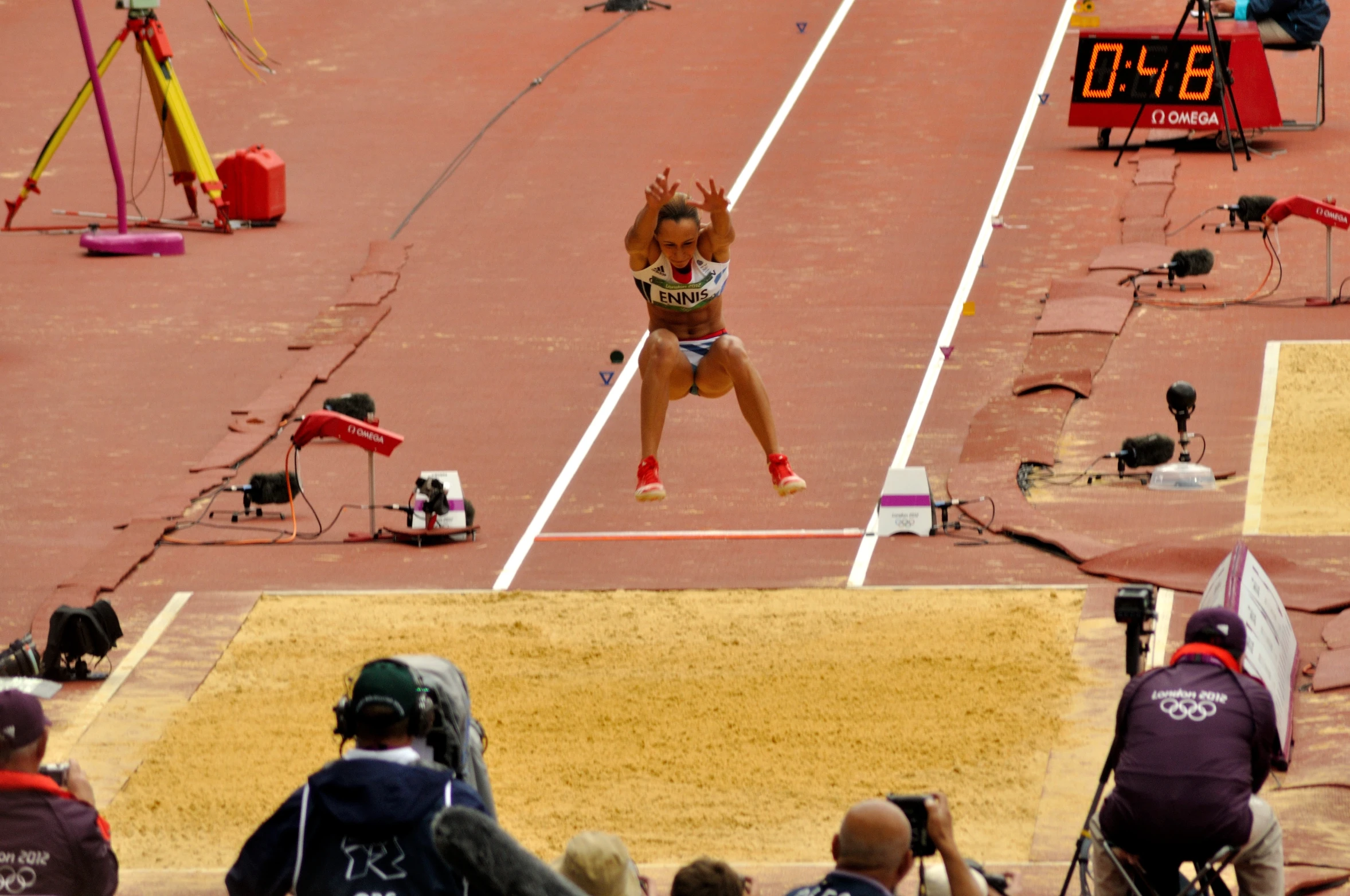 a female athlete jumping in the air during a competition