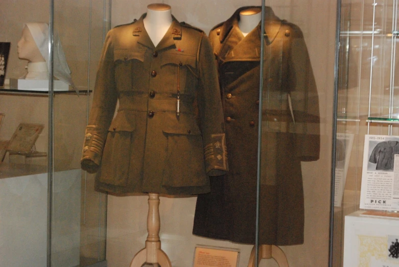 two coat cases sit on display with mannequins dressed in trench coats