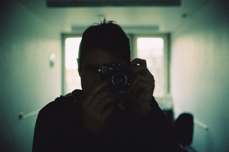 a man holding up a camera in front of his face