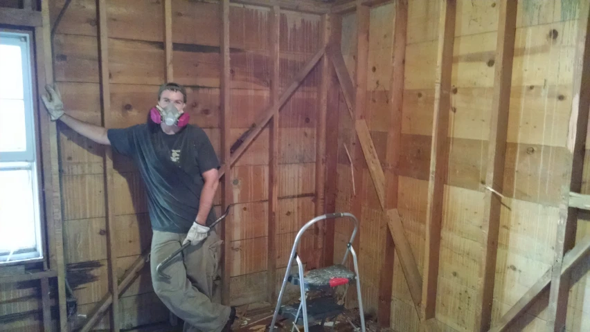 a man wearing headphones and an apron standing in an unfinished building