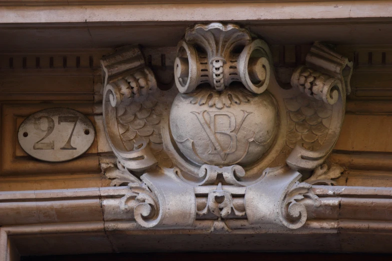 a crest mounted on a building with two faces in it