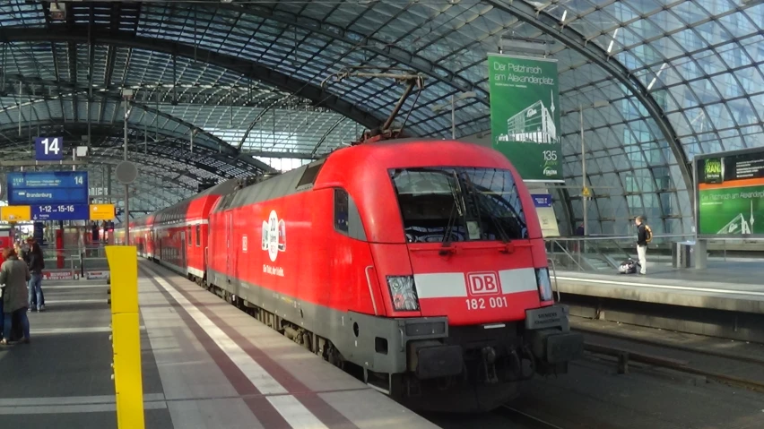 a red train sitting in front of a train station