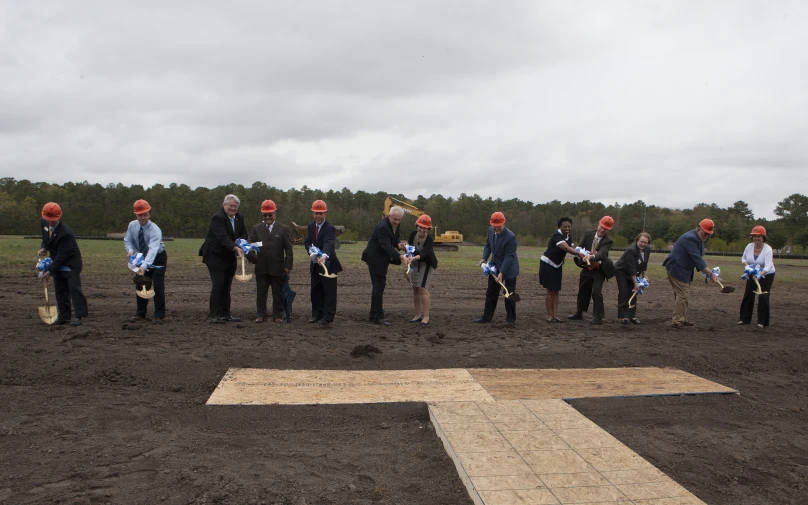 a group of men are in a field with construction equipment