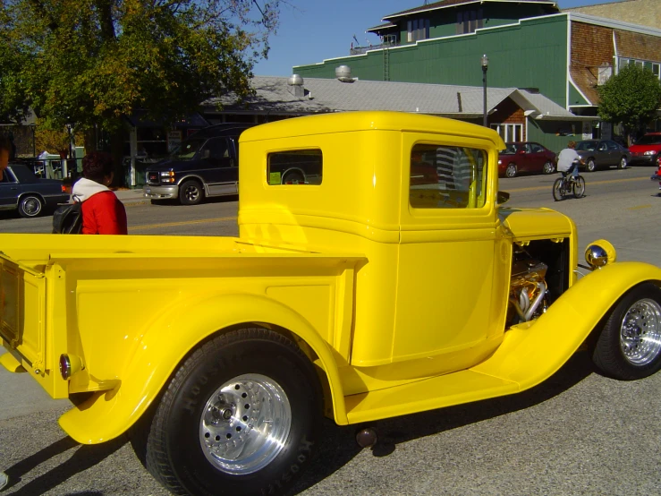 a yellow pick up truck is shown with an open hood