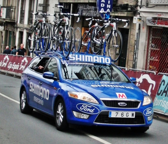 a blue car with some bikes on its roof