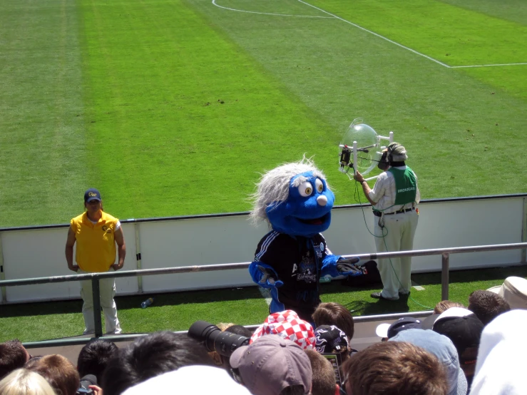 the mascot is shaking hands with the referee