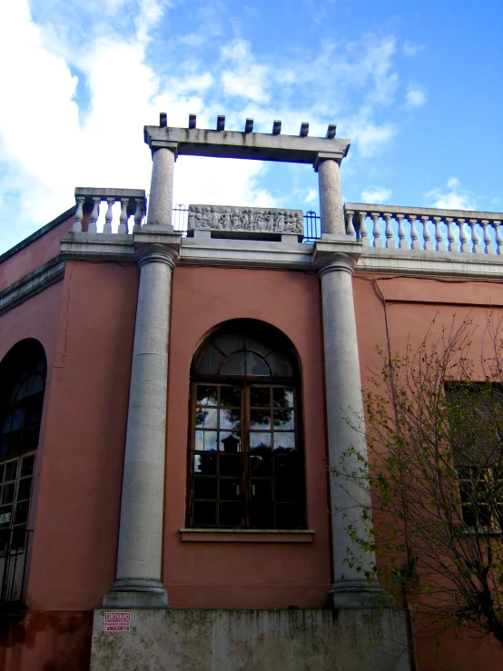 the window of a building has a small balcony on top