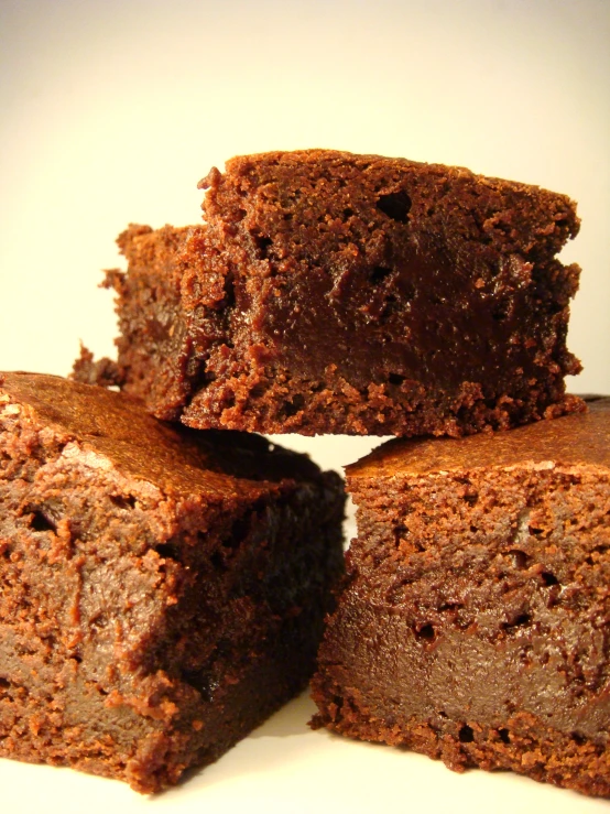 pieces of brownie sitting on a plate, on a table