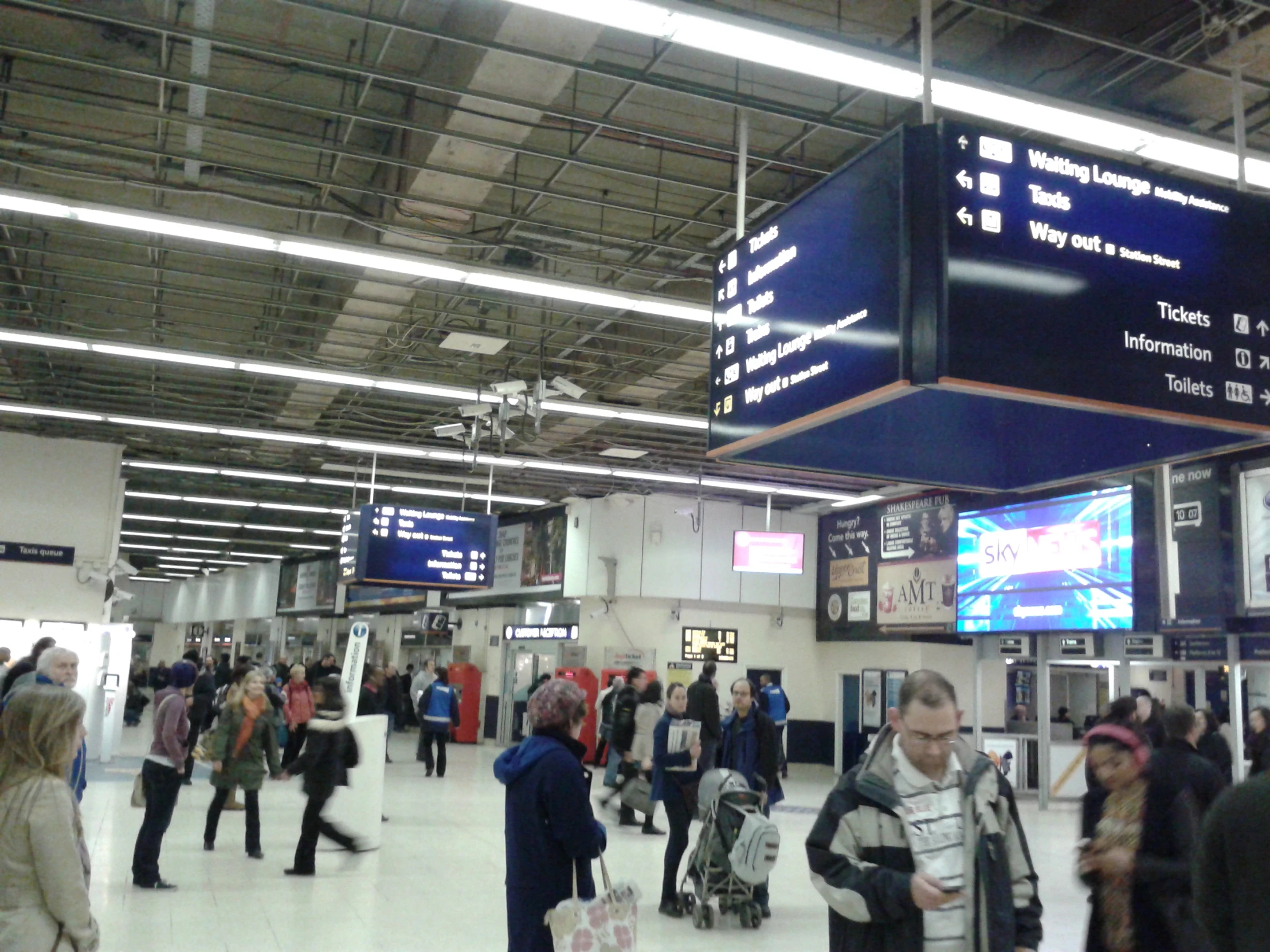 a large crowd of people are walking around an airport