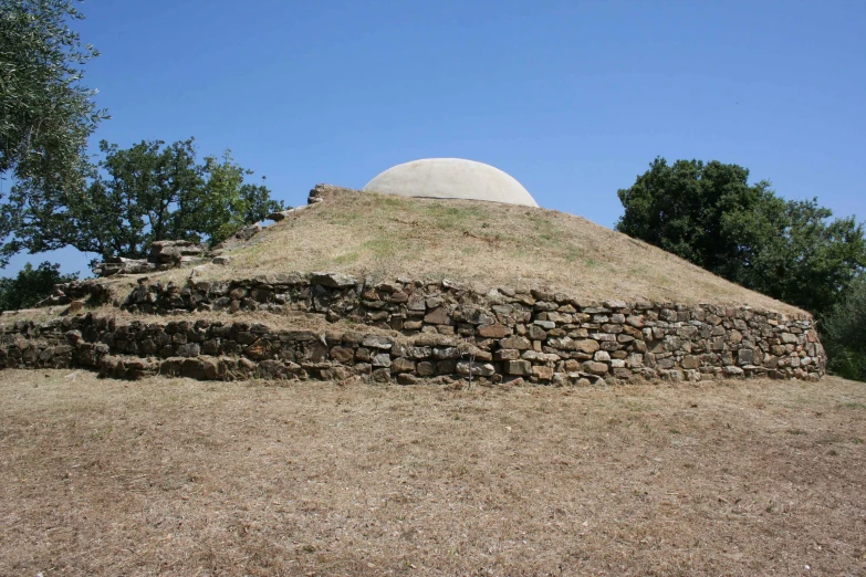 a very large rock structure sitting in the middle of some grass