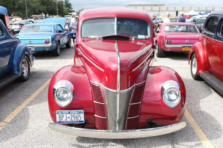 an old red car is parked in the parking lot