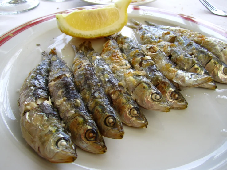 an assortment of fish on a plate with a slice of lemon