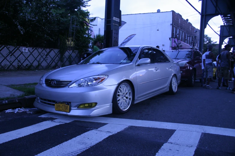 a very clean silver car is parked on the street