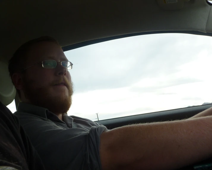 a man sitting in the driver's seat of a car