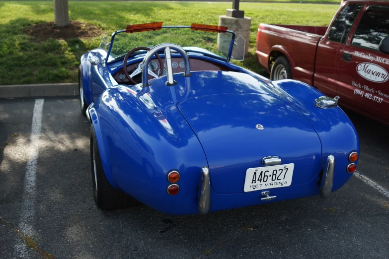 a blue sports car is in the lot next to a red truck