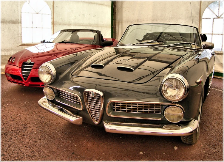 vintage cars with hoods are parked in an outdoor garage