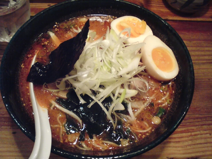 soup is shown with eggs and onions on top