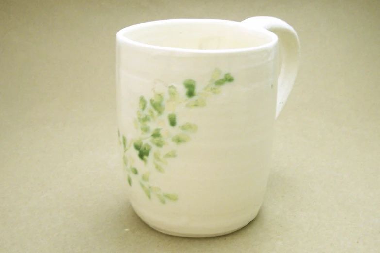 the ceramic cup is decorated with flowers on the handle