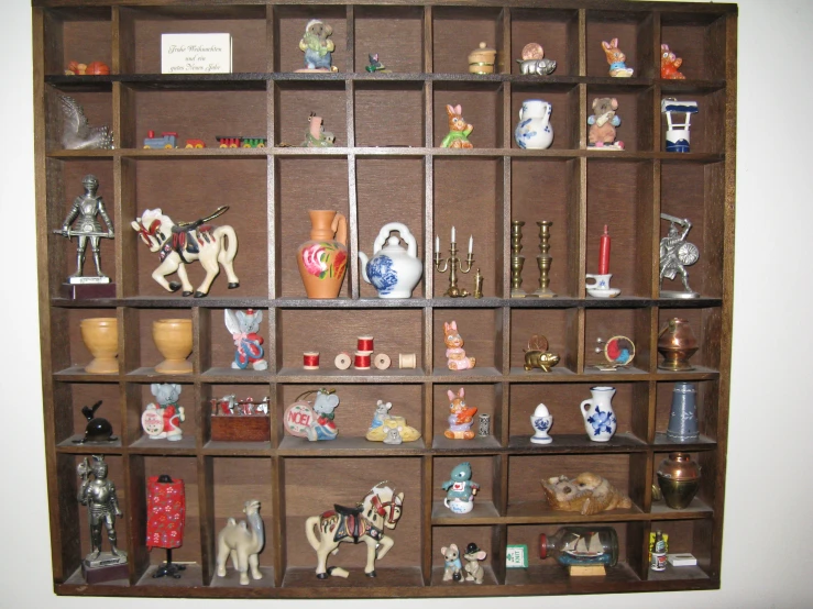 a wall shelf with several different items in a glass case