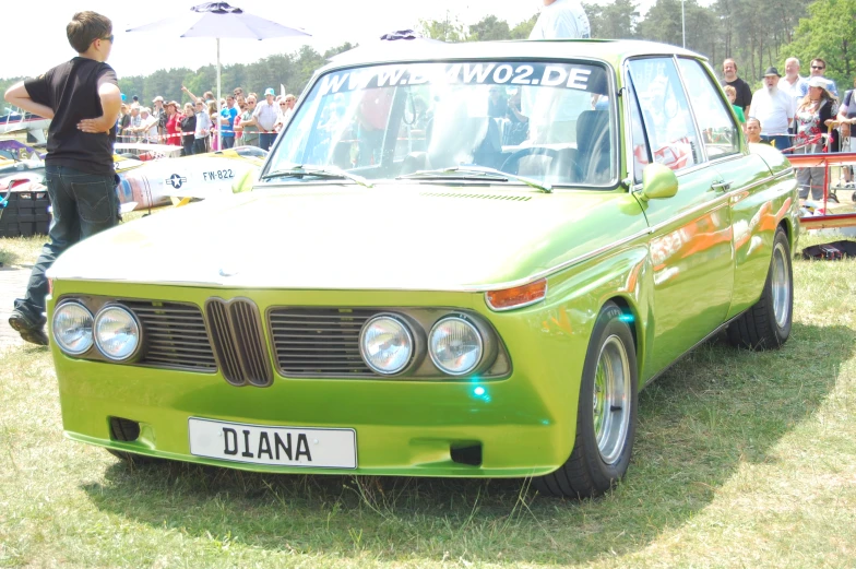 a green car parked in front of a wooden table