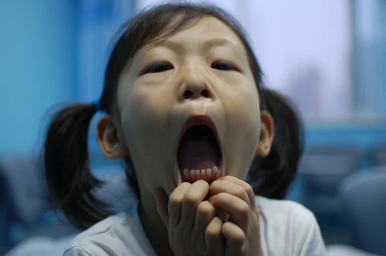 a small child is in front of the camera with their mouth open