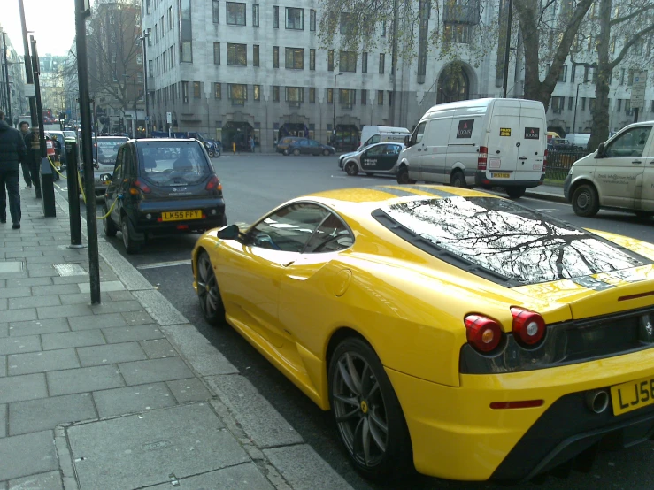 yellow sports car parked on street next to sidewalk