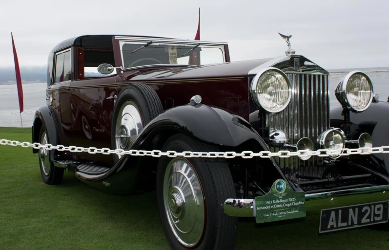 a vintage car parked near a body of water