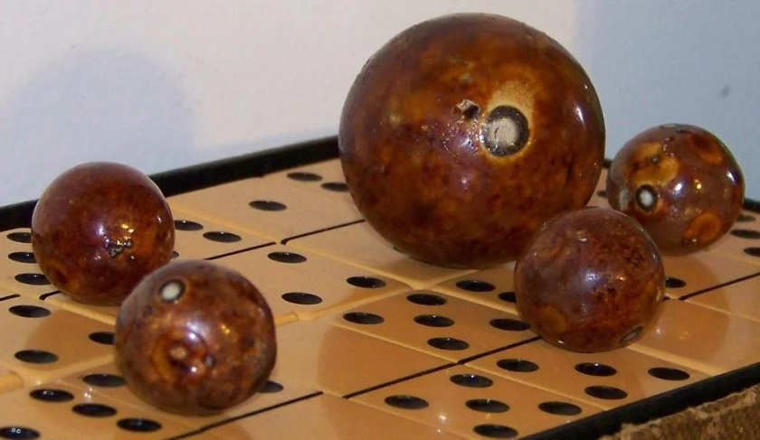 three different sized wooden balls placed on one another