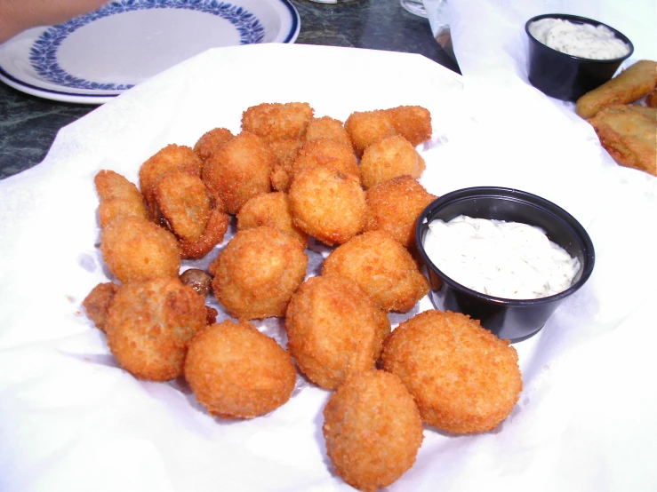 a table with a plate and some food and dipping sauce