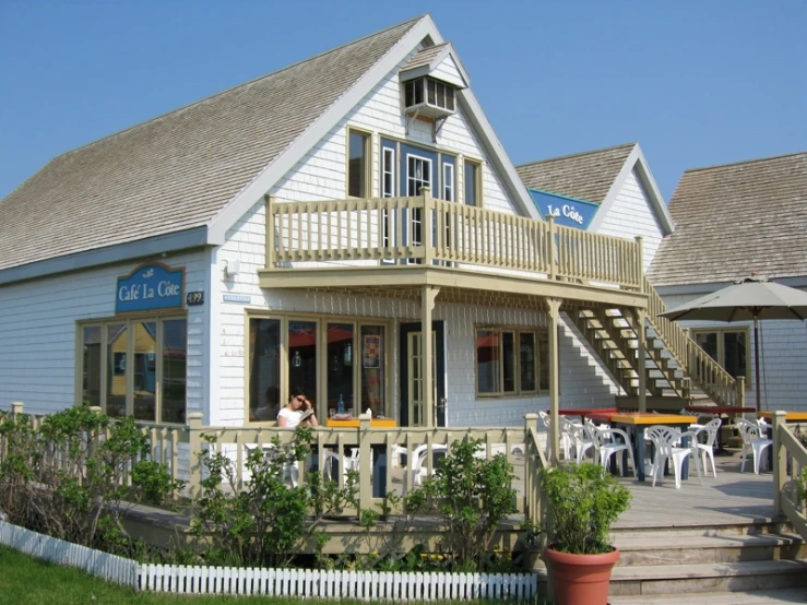 an outside s of a store front with tables and chairs