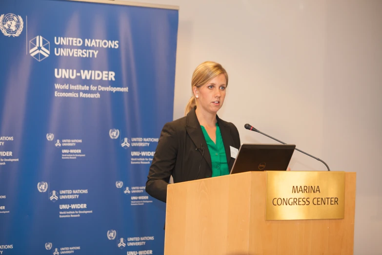 a woman speaking into a microphone next to a podium